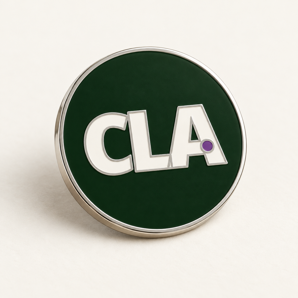 Digital mock-up: angled view of the CLA soft-enamel pin showing the raised nickel rim and letter outlines.